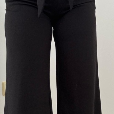 Calças pretas largas com cinto e suéter branco