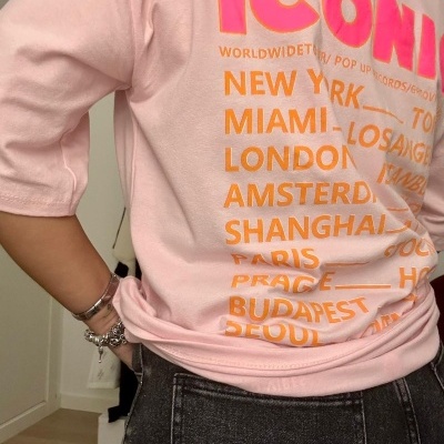 T-shirt rosa com texto colorido e calças pretas de ganga