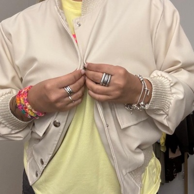 Casaco bege com botões sobre t-shirt amarela