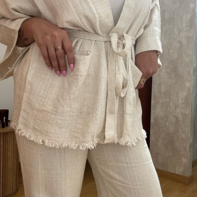 Conjunto bege claro em tecido tipo linho, casaco com cinto e bolso, calças compridas combinando.