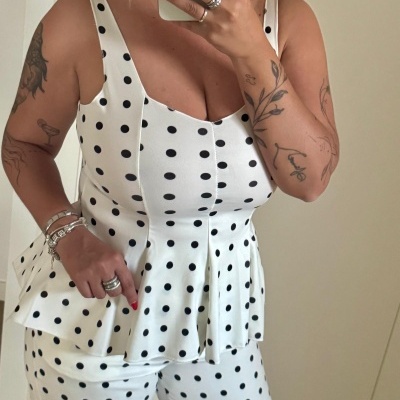 Conjunto branco com bolinhas pretas, top de alças largas e calças, tecido fluído, fotografia interior.