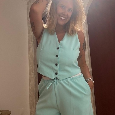 Conjunto de colete e calças azul claro com botões pretos e cordão na cintura