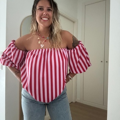 Mulher vestindo blusa listrada vermelha e branca e calças de ganga