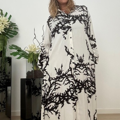 Vestido comprido branco com padrão preto abstrato em mulher sorridente