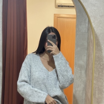 Camisola de malha cinzenta com decote em V, textura felpuda, refletida num espelho com moldura dourada