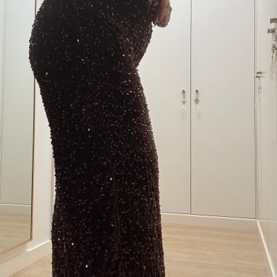 Calças castanho escuro com lantejoulas brilhantes, usadas por pessoa em interior