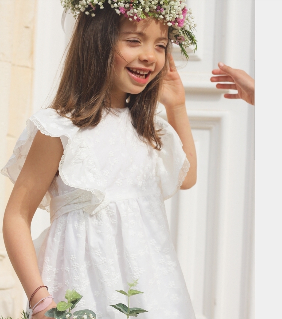 Menina com vestido branco floral e coroa de flores
