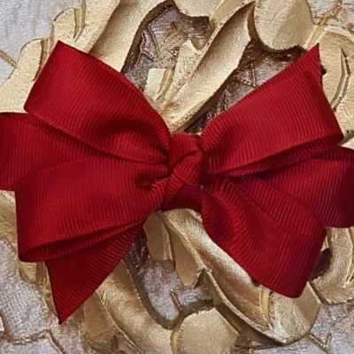 Laço vermelho decorativo sobre fundo ornamental dourado