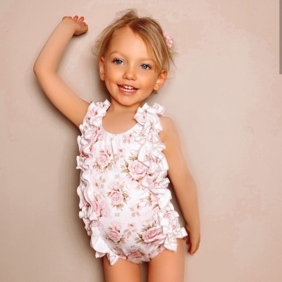 Fato de banho floral rosa e branco para menina com folhos, criança loira a sorrir