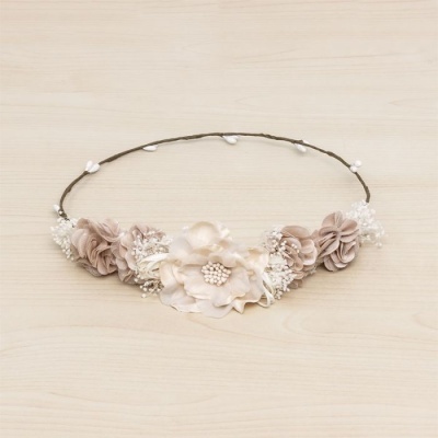 aro de cabelo com flores artificiais bege e castanho claro sobre madeira