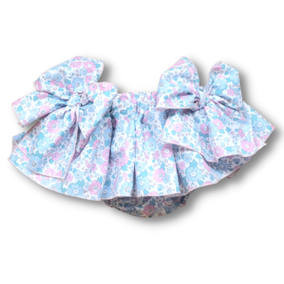 Calcinha de bebé com padrão floral azul, rosa e branco e fitas decorativas grandes