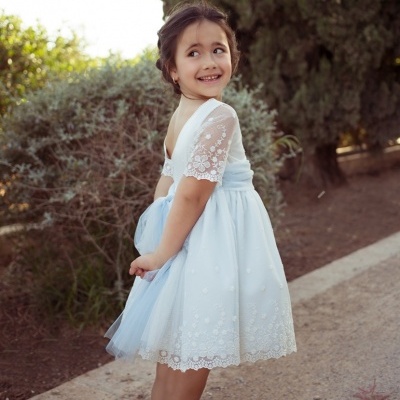 Menina com vestido azul claro com renda branca e tule, ao ar livre numa trilha