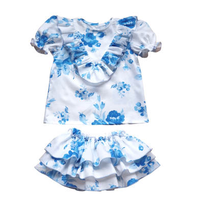 Conjunto infantil blusa e saia com padrão floral azul e branco.