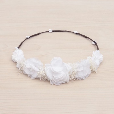 Grinalda com flores de tecido branco sobre base castanha