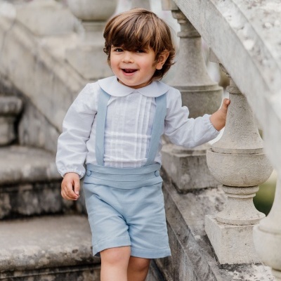 Criança vestida com roupa clássica a subir escadas de pedra