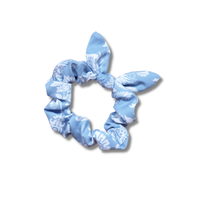 Elástico de cabelo scrunchie azul claro com padrão floral branco e detalhes tipo 'orelhas'