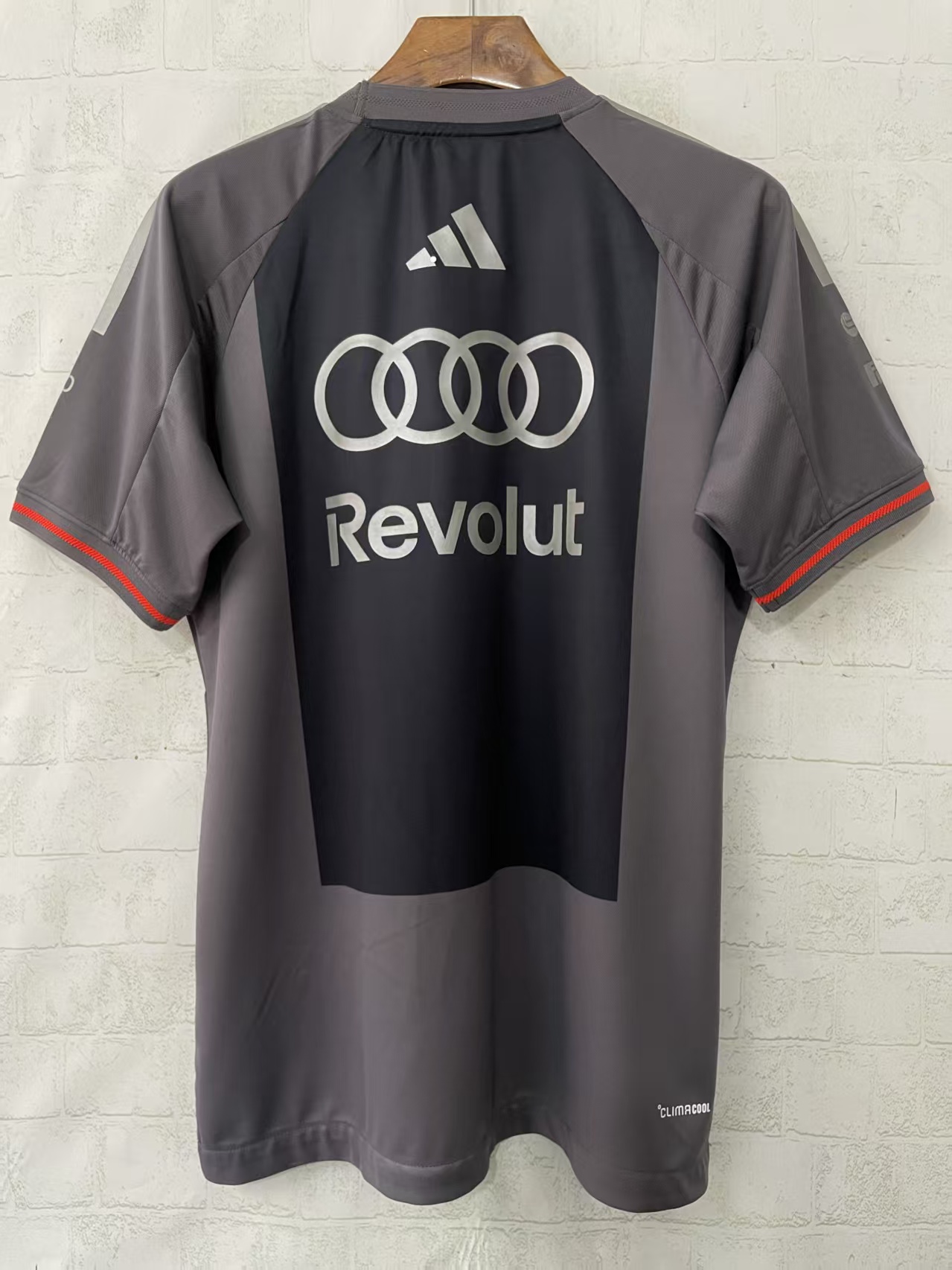 T-shirt desportiva cinzenta e preta com logótipos Adidas, Audi e Revolut