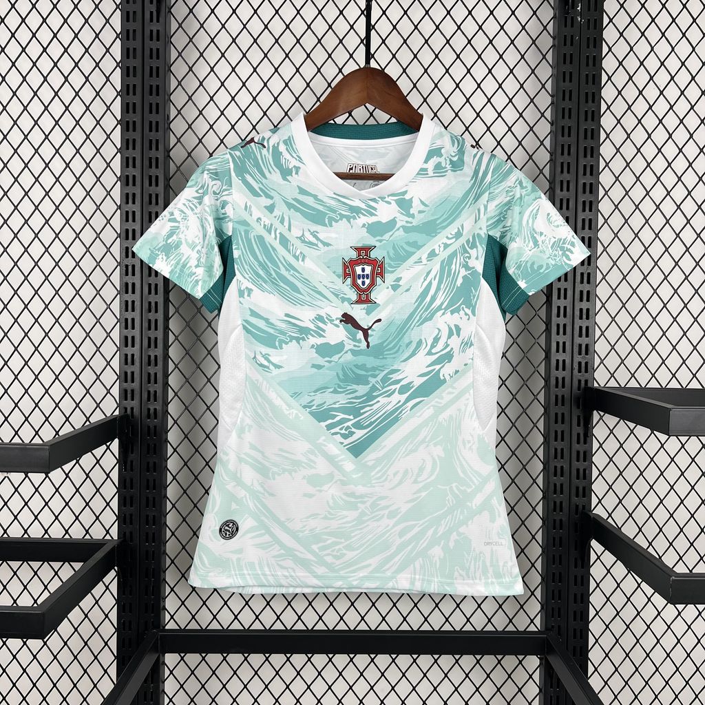 O orgulho das Quinas com um toque moderno e inspirado no oceano! Apresentamos a Camisola Feminina Portugal 2026, modelo alternativo (Away) na Versão Adepto, desenvolvida pela Puma. Inspirada na herança marítima do país, esta camisola une um design autêntico e moderno a um corte feito para a silhueta feminina, perfeita para exibires o teu apoio à Seleção com estilo. 🌊 Design com Alma Marítima O equipamento alternativo de Portugal para o Mundial 2026 é uma homenagem à ligação do país ao mar e à sua história de exploração . Base Branca e Padrão "Green Lagoon": A camisola apresenta uma base branca, sobreposta por amplos padrões ondulados na cor verde-lagoa (Green Lagoon) . Este design fluido captura a graça e a força do oceano, uma celebração da alma marítima portuguesa. Emblema Central: O escudo da Federação Portuguesa de Futebol e o logótipo Puma figuram ao centro do peito, numa abordagem moderna que se alinha com o design do equipamento usado pelos jogadores em campo . Corte Feminino Exclusivo: Modelo com corte específico para mulher e um ajuste regular (Regular Fit) . Proporciona um caimento confortável e versátil, ideal para o dia a dia. ⚡ Tecnologia e Conforto Esta versão réplica foi desenhada para o máximo conforto, mantendo a autenticidade do equipamento: Tecnologia dryCELL: Sistema avançado de gestão de humidade que absorve e dispersa o suor, mantendo-te seca, fresca e confortável, seja no estádio ou no dia a dia . Material RE:FIBRE: Fabricada com, pelo menos, 95% de poliéster reciclado a partir de resíduos têxteis, uma iniciativa que alia performance à sustentabilidade . Painéis de Malha: Inserções estratégicas em zonas de maior transpiração que melhoram a respirabilidade e a ventilação . Gola e Acabamentos: Apresenta uma gola redonda (crew neck) e acabamentos detalhados para um visual premium . Veste a garra e a paixão de Portugal com estilo e autenticidade. 🇵🇹🏆