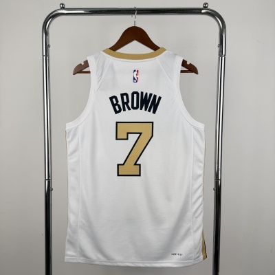 Camisola branca de basquetebol com nome BROWN e número 7 pendurada num suporte metálico.