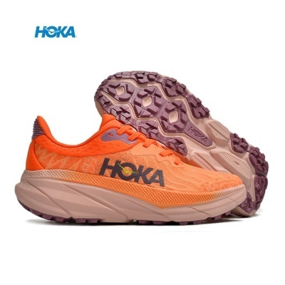 Ténis de corrida laranja com sola rosa claro e preta, logótipo HOKA no lado