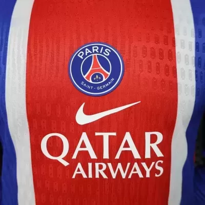 Detalhe de camisola desportiva vermelha com emblema Paris Saint-Germain e texto Qatar Airways