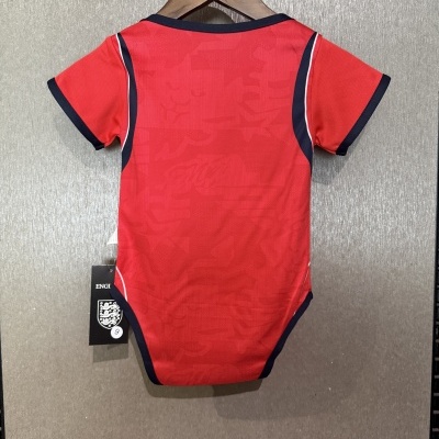 Body vermelho com detalhes a preto e branco pendurado em cabide de madeira