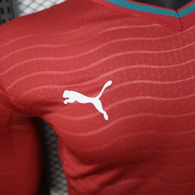 Camisola desportiva vermelha com logo branco da Puma e gola azul turquesa e vermelha