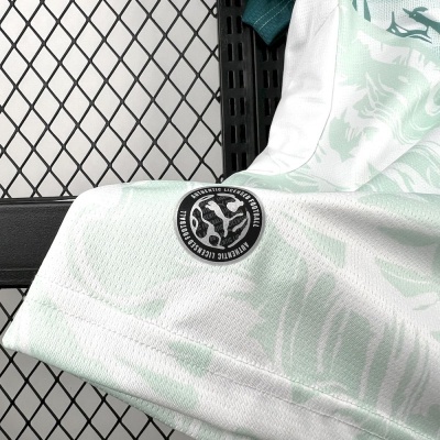 Peça de roupa branca com estampado verde claro e etiqueta redonda preta