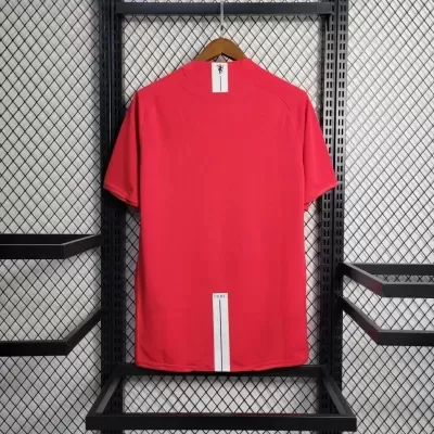 T-shirt desportiva vermelha com gola alta e etiqueta MUFC na parte de trás