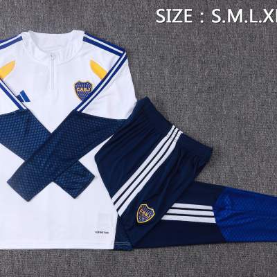 Conjunto desportivo branco e azul com emblema CABJ sobre fundo cinzento