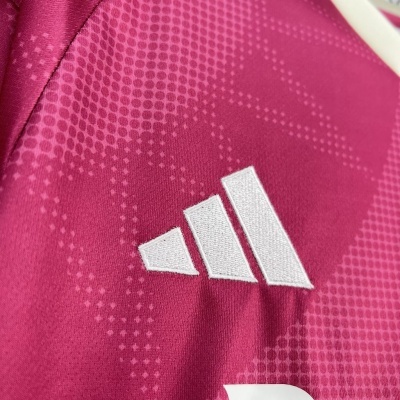Tecido rosa com padrão de pontos e logótipo Adidas branco bordado.