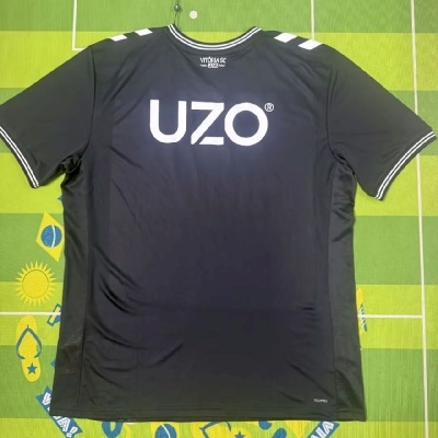 Camisola preta desportiva com logótipos brancos e fundo verde com desenhos
