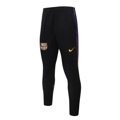 Calças desportivas pretas com listra roxa e amarela, logótipos FC Barcelona e Nike.