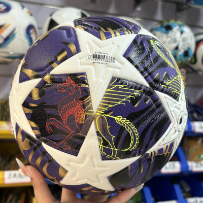 Bola de futebol branca com padrões coloridos e código de barras, segurada à frente de várias outras bolas em prateleiras.
