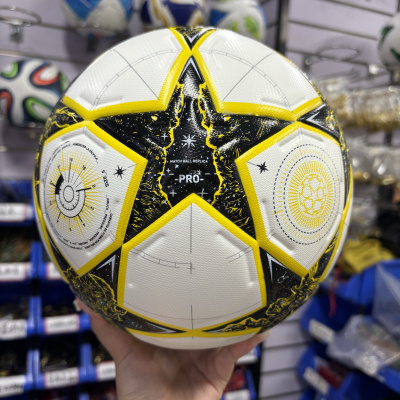 Bola de futebol branca amarela e preta com padrão de estrela em loja de desporto