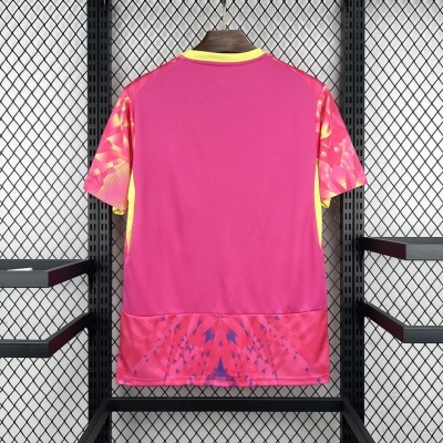 T-shirt desportiva rosa com padrões geométricos pendurada numa estrutura de metal