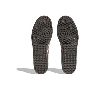 Solados castanhos escuros de sapatilhas adidas com padrão geométrico.