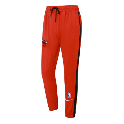 Calças desporto vermelhas com risca lateral preta e logótipos NBA, Nike e Chicago Bulls.
