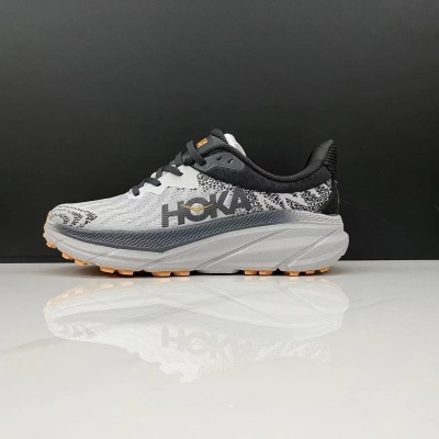 Ténis HOKA branco e preto sobre superfície branca com fundo preto