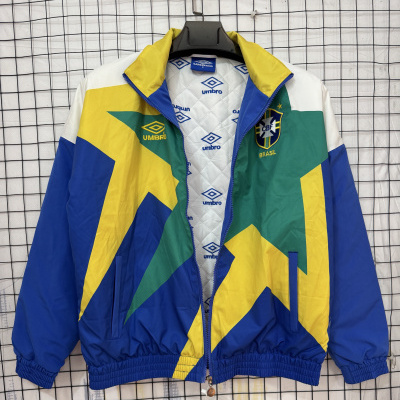 Casaco desportivo colorido com fecho azul e logos da Umbro e Brasil