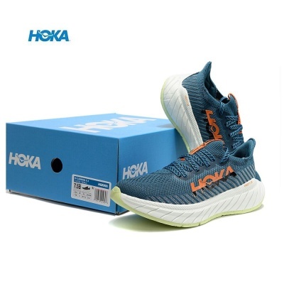 Ténis de corrida HOKA W CARBON X 3 azul com sola branca e logo laranja junto a caixa azul HOKA