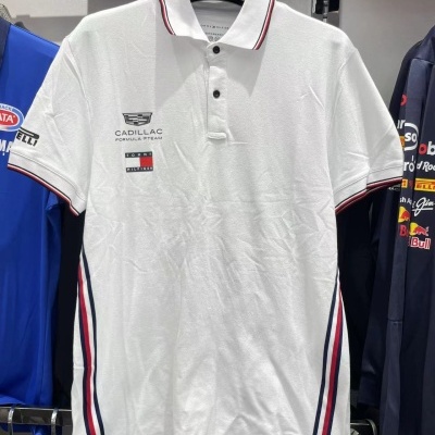 Polo branco com logos CADILLAC FORMULA 1 TEAM e TOMMY HILFIGER, gola e punhos com riscas vermelhas e pretas em loja