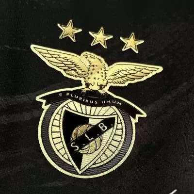 Emblema dourado e preto com eagle, estrelas, bola de futebol e S.L.B sobre tecido preto