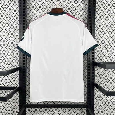 T-shirt branca com gola verde e detalhes vermelhos pendurada em cabide