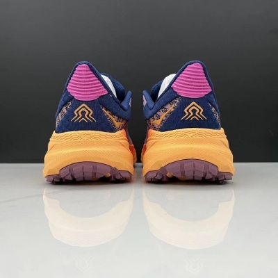 Ténis desportivos com sola laranja e detalhes azul escuro, roxo e rosa vistos pela parte traseira