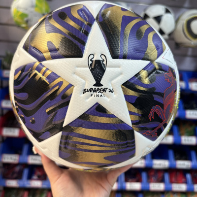 Bola de futebol branca com padrão dourado, preto e roxo com texto BUDAPEST 26 FINAL e símbolo de taça.