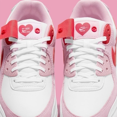 Par de sapatilhas brancas e rosas com detalhes vermelhos e etiquetas com corações vermelhos