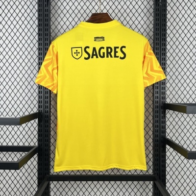 T-shirt desportiva amarela com manga padrão geométrico laranja e logo SAGRES nas costas pendurada em cabide