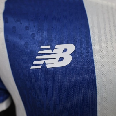 pormenor de camisola desportiva azul e branca com logótipo branco da New Balance