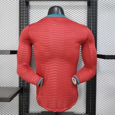 Camisola desportiva vermelha com padrão ondulado e detalhes azuis e vermelhos